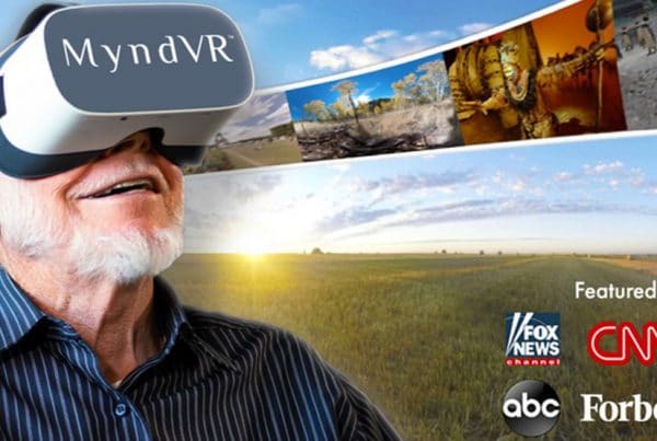 Older adult man with MyndVR headset on smiling while enjoying VR library.